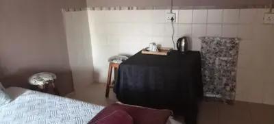 a bedroom with a bed and a table in a room at Walalawasala in Polokwane