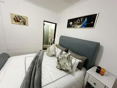 a dog sitting on a bed in a bedroom at Chilled Vibe Lodge in Soshanguve