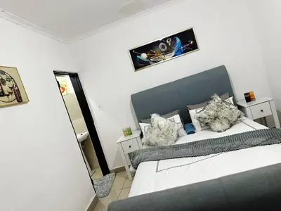 a bedroom with a king sized bed and a mirror at Chilled Vibe Lodge in Soshanguve