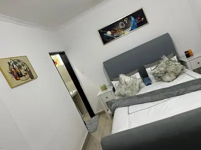 a small bedroom with a bed and a mirror at Chilled Vibe Lodge in Soshanguve