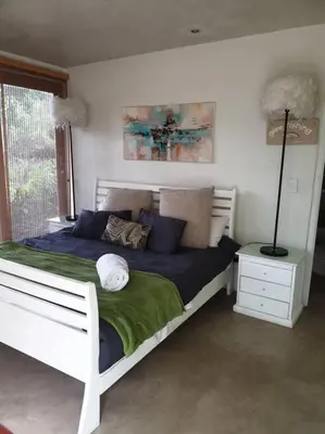 a bedroom with a white bed with blue pillows at Glenferness AH Villa in Midrand