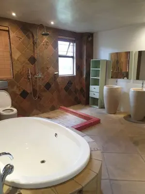 a bathroom with a tub and two sinks and a shower at Glenferness AH Villa in Midrand