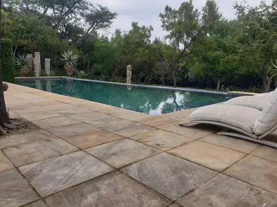 a swimming pool in a yard with a couch next to it at Glenferness AH Villa in Midrand