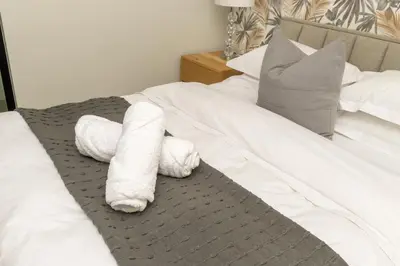 a white stuffed animal laying on a bed at Mvilo, Luxury Apartment, Ellipse Waterfall in Midrand