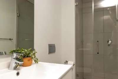 a bathroom with a white sink and a shower at Mvilo, Luxury Apartment, Ellipse Waterfall in Midrand