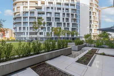 a garden in front of a tall building at Mvilo, Luxury Apartment, Ellipse Waterfall in Midrand