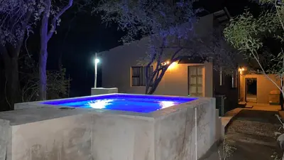 a swimming pool at night with blue lights at Ikigai@4617 Cottage in Marloth Park