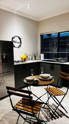 a kitchen with a table and two chairs and a counter at Ikigai@4617 Cottage in Marloth Park