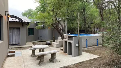 a picnic table and a bench in a yard at Ikigai@4617 Cottage in Marloth Park