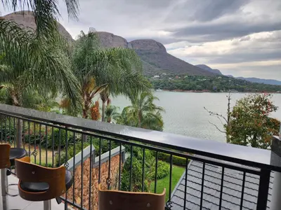 a balcony with a view of a lake and mountains at BondMakers at Kosmos in Hartbeespoort