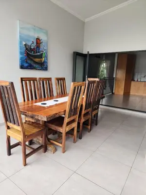 a wooden dining room table with chairs and a painting at BondMakers at Kosmos in Hartbeespoort