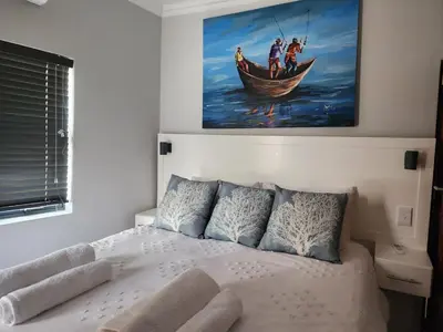 a bedroom with a bed with a painting on the wall at BondMakers at Kosmos in Hartbeespoort
