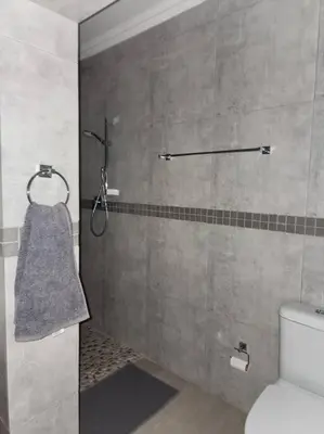 a bathroom with a shower with a toilet and a towel at BondMakers at Kosmos in Hartbeespoort