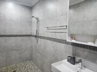 a bathroom with a shower and a sink and a mirror at BondMakers at Kosmos in Hartbeespoort