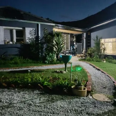 a garden in front of a house at night at Avalon Cottages in Barberton