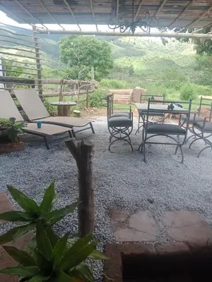 a patio with chairs and a table and a table and chairs at Avalon Cottages in Barberton
