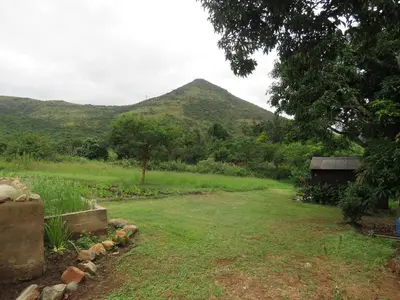 a view of a field with a mountain in the background at Avalon Cottages in Barberton
