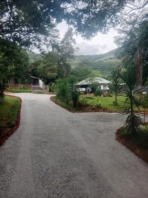 a driveway with a house in the distance at Avalon Cottages in Barberton