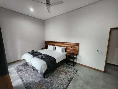 a bedroom with two beds and a rug at Bald Ibis (856 Highland Gate) in Dullstroom