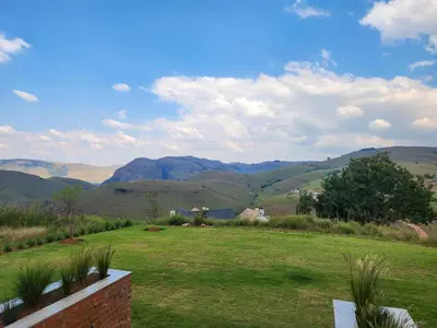 a view of a green field with mountains in the background at Bald Ibis (856 Highland Gate) in Dullstroom
