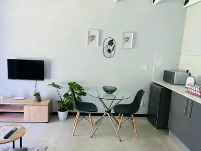 a dining room with a glass table and two chairs at Cozy Guest Suite 2-with back up power in Midrand