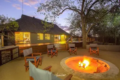 a patio with a fire pit in front of a house at Luxury GuesthouseCo Butterfly House in Marloth Park