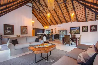 a living room with a couch and a table at Luxury GuesthouseCo Butterfly House in Marloth Park