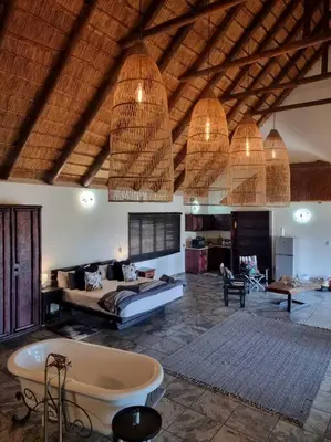 a large living room with a tub and a couch at Luxury GuesthouseCo RiverDance in Marloth Park