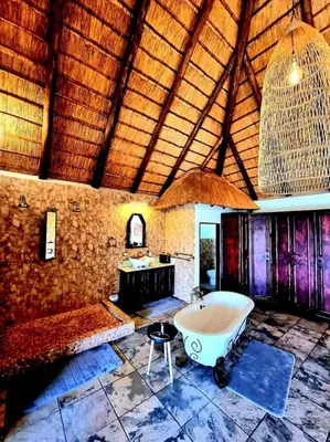 a large bathroom with a tub and a sink at Luxury GuesthouseCo RiverDance in Marloth Park