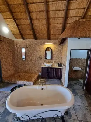 a large bathroom with a tub and a sink at Luxury GuesthouseCo RiverDance in Marloth Park