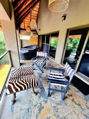 a living room with two chairs and a couch at Luxury GuesthouseCo RiverDance in Marloth Park