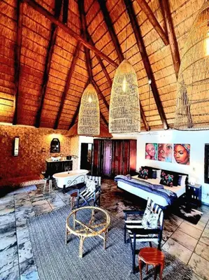 a large room with a couch and tables in it at Luxury GuesthouseCo RiverDance in Marloth Park