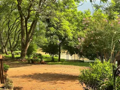 a park with a lot of trees and a dirt road at Faith Cabin in Waterval-Onder