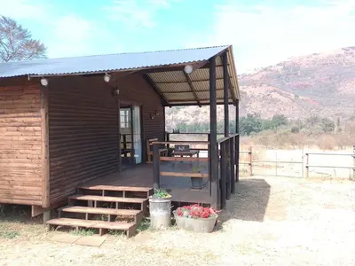 a small building with a staircase and a porch at Faith Cabin in Waterval-Onder