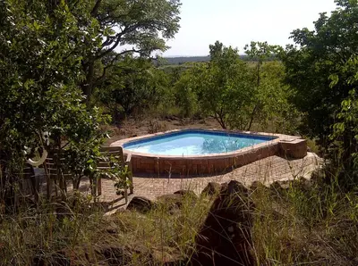 a swimming pool in the middle of a field at Pumula Game Farm in Eersbewoond