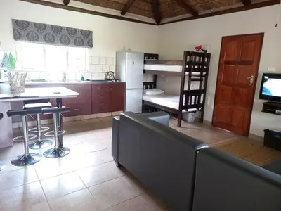 a kitchen with a couch and a table and a refrigerator at Pumula Game Farm in Eersbewoond