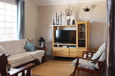 a living room with a couch and a television at Pumula Game Farm in Eersbewoond