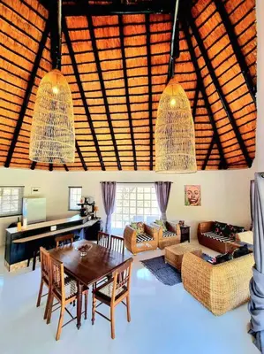 a living room with a table and chairs and a piano at Luxury GuesthouseCo HiddenHouse in Marloth Park