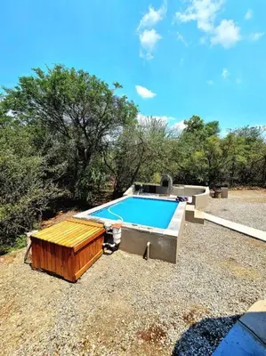 a small swimming pool in a yard with trees at Luxury GuesthouseCo HiddenHouse in Marloth Park
