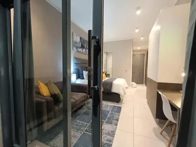 a hotel room with a bed and a sliding glass door at Comfort at 1320 Menlyn Maine Residences in Pretoria