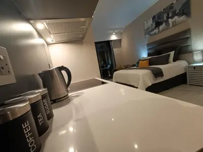 a hotel room with a bed and a kitchen with a counter at Comfort at 1320 Menlyn Maine Residences in Pretoria