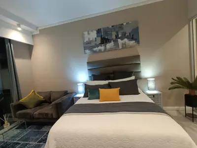 a bedroom with a large bed and a couch at Comfort at 1320 Menlyn Maine Residences in Pretoria