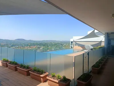 a balcony with potted plants and a view of the water at Comfort at 1320 Menlyn Maine Residences in Pretoria