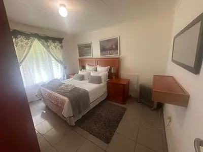a bedroom with a bed and a window at The Lake Villa in Benoni