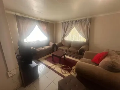 a living room with a couch and a tv at The Lake Villa in Benoni