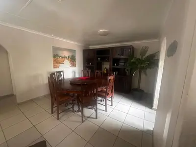 a kitchen and dining room with a table and chairs at The Lake Villa in Benoni