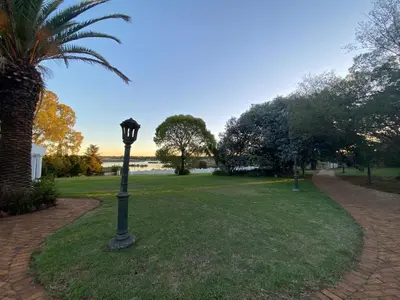 a street light in a park with a palm tree at The Lake Villa in Benoni