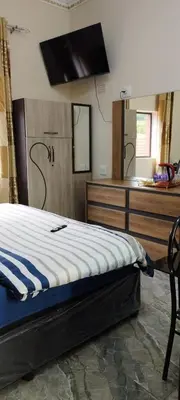 a bedroom with a bed and a sink and a mirror at Whitehouse Lodge Benoni in Benoni