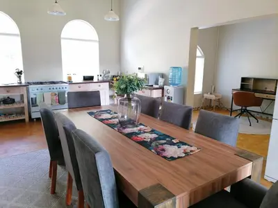 a dining room with a wooden table and chairs at Shingalana Cottages in White River