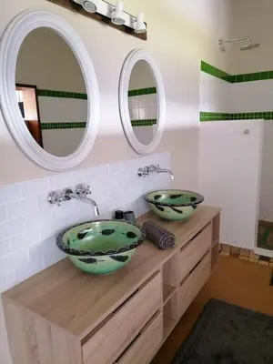 a bathroom with two sinks and two mirrors at Shingalana Cottages in White River